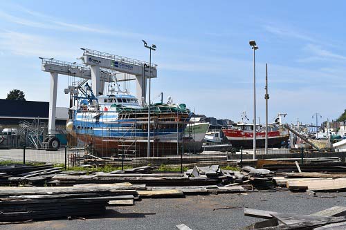 Élévateur à bateau à Port-en-Bessin (en arrière-plan), 24 juin 2021. © Théo Lebouc, 2021..